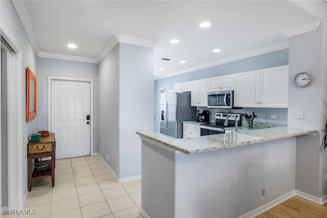 kitchen with a peninsula, light stone countertops, ornamental molding, stainless steel appliances, and white cabinetry