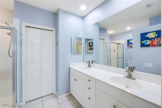 bathroom with a closet, a sink, tile patterned flooring, and a shower stall