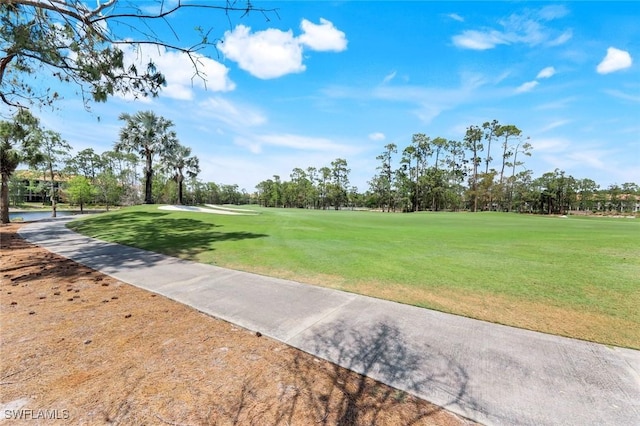 surrounding community featuring view of golf course and a yard