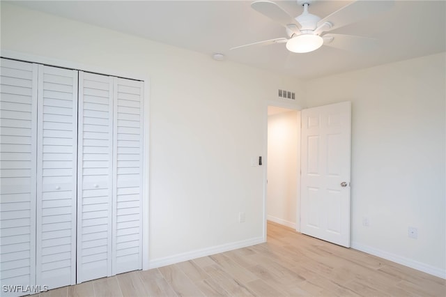 unfurnished bedroom featuring a closet, light wood-style flooring, baseboards, visible vents, and ceiling fan