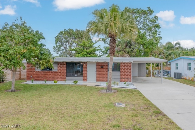 single story home with concrete driveway, central air condition unit, brick siding, a front lawn, and a carport