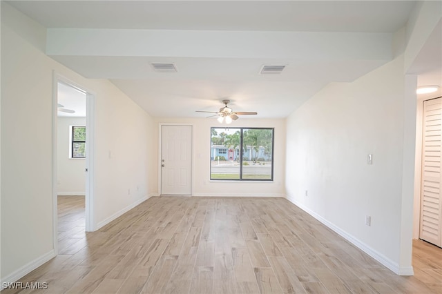 unfurnished room with baseboards, visible vents, light wood-style floors, and a ceiling fan
