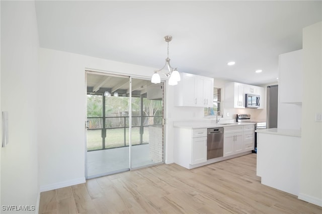 kitchen featuring white cabinetry, light countertops, a sink, and stainless steel appliances