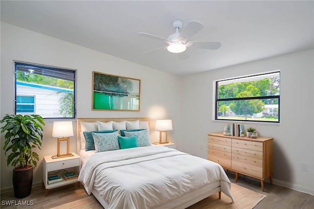 bedroom featuring baseboards, ceiling fan, and wood finished floors