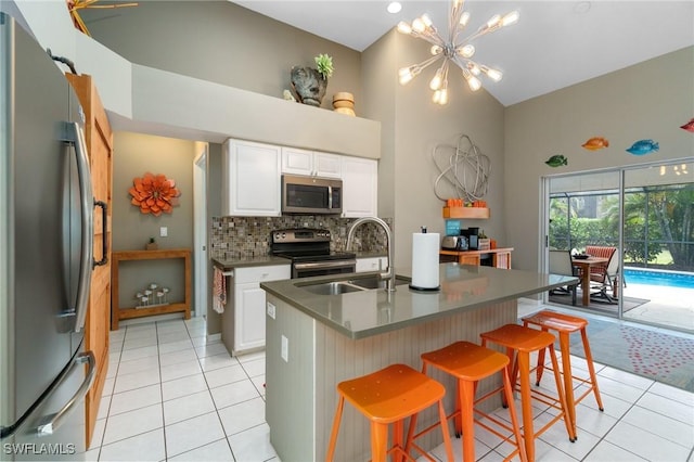 3701 Bali Ln, Estero, FL 33928 - kitchen with a sink, backsplash, appliances with stainless steel finishes, light tile patterned floors, and an inviting chandelier