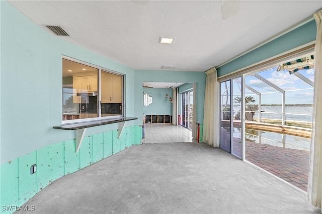 11915 Island Ave, Matlacha, FL 33993 - kitchen featuring unfinished concrete flooring, fridge, a water view, a sunroom, and visible vents