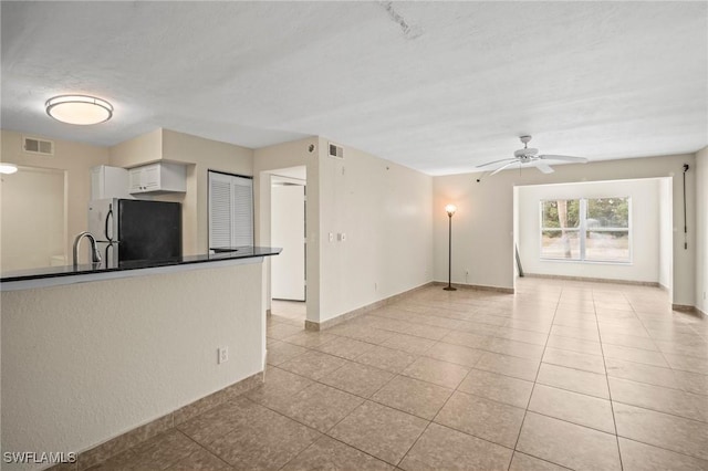 8245 Ibis Club Dr Unit 401, Naples, FL 34104 - interior space featuring light tile patterned flooring, white cabinets, visible vents, dark countertops, and freestanding refrigerator