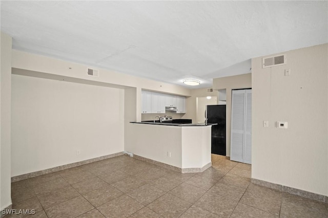 8245 Ibis Club Dr Unit 401, Naples, FL 34104 - kitchen featuring freestanding refrigerator, dark countertops, under cabinet range hood, and visible vents