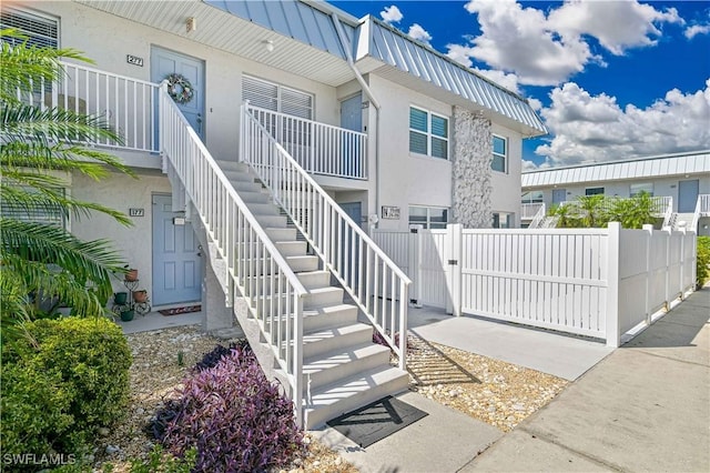 entrance to property with stucco siding and fence