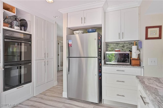 231 Kingston Dr, Fort Myers, FL 33905 - kitchen featuring stainless steel appliances, white cabinets, light stone countertops, light wood finished floors, and backsplash