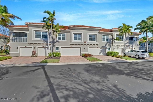 8521 Violeta St Unit 101, Estero, FL 34135 - multi unit property featuring stucco siding, a tiled roof, an attached garage, and driveway