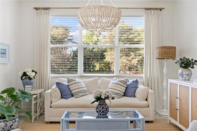 living area with a notable chandelier, light colored carpet, and a healthy amount of sunlight