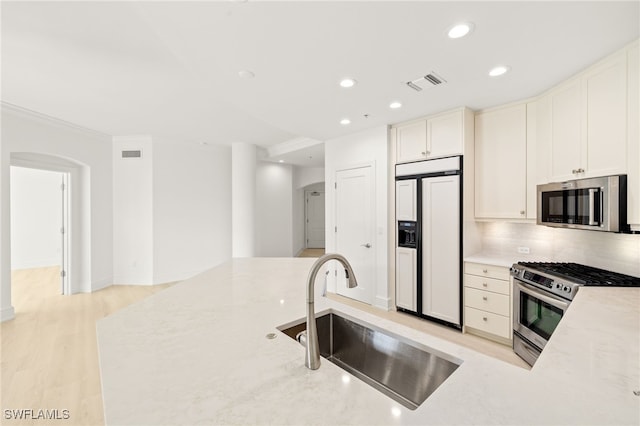 9123 Strada Pl Unit 7316, Naples, FL 34108 - kitchen featuring stainless steel appliances, a sink, arched walkways, recessed lighting, and backsplash