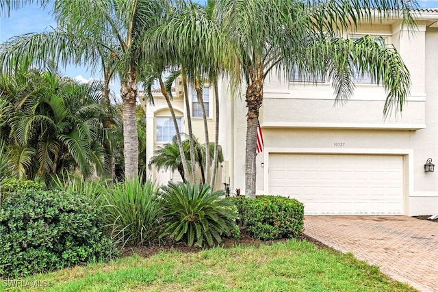 10327 Carolina Willow Dr, Fort Myers, FL 33913 - view of front facade featuring stucco siding, decorative driveway, and an attached garage