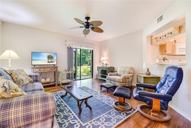 9648 Windsor Gardens Ln Unit 104, Fort Myers, FL 33919 - living area with a ceiling fan, wood finished floors, and baseboards