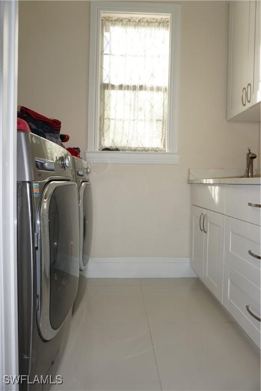 3393 21st Ave SW, Naples, FL 34117 - laundry room featuring separate washer and dryer, cabinet space, and tile patterned floors