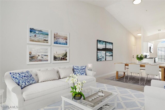 4940 Cougar Ct S Unit 201, Naples, FL 34109 - living room featuring baseboards and lofted ceiling