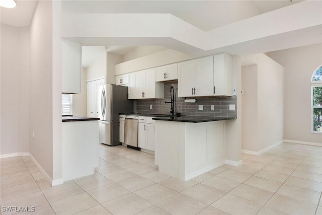 4940 Cougar Ct S Unit 201, Naples, FL 34109 - kitchen with tasteful backsplash, lofted ceiling, stainless steel appliances, dark countertops, and white cabinets
