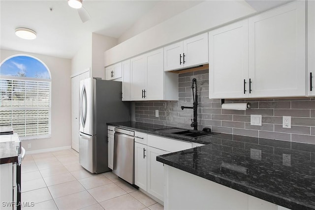 4940 Cougar Ct S Unit 201, Naples, FL 34109 - kitchen with white cabinetry, light tile patterned floors, stainless steel appliances, backsplash, and a sink