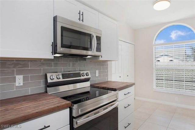 4940 Cougar Ct S Unit 201, Naples, FL 34109 - kitchen with decorative backsplash, white cabinets, stainless steel appliances, and butcher block counters