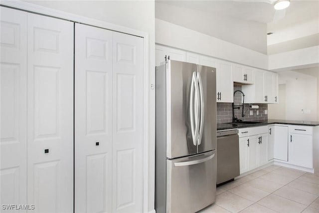 4940 Cougar Ct S Unit 201, Naples, FL 34109 - kitchen featuring light tile patterned floors, stainless steel appliances, decorative backsplash, a sink, and dark countertops