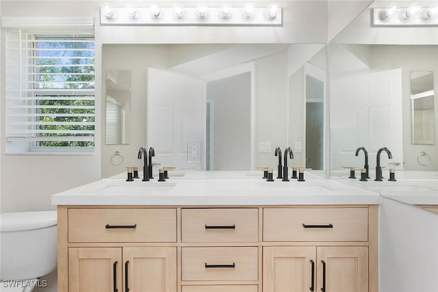 4940 Cougar Ct S Unit 201, Naples, FL 34109 - bathroom featuring double vanity, a sink, toilet, and plenty of natural light