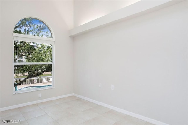 4940 Cougar Ct S Unit 201, Naples, FL 34109 - spare room with baseboards and a towering ceiling