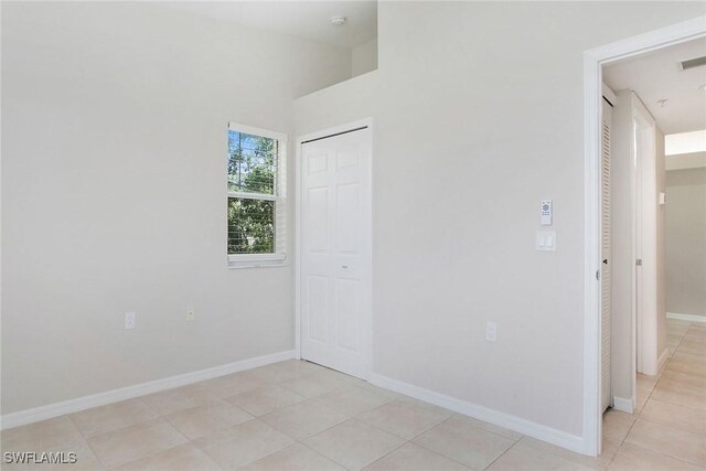 4940 Cougar Ct S Unit 201, Naples, FL 34109 - empty room with light tile patterned flooring and baseboards