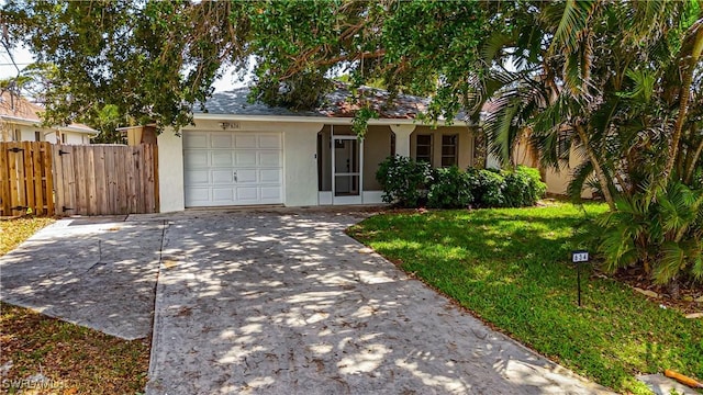 single story home featuring a front yard, a garage, fence, concrete driveway, and stucco siding