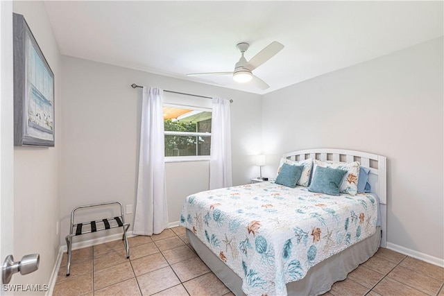 bedroom featuring baseboards, a ceiling fan, and light tile patterned flooring