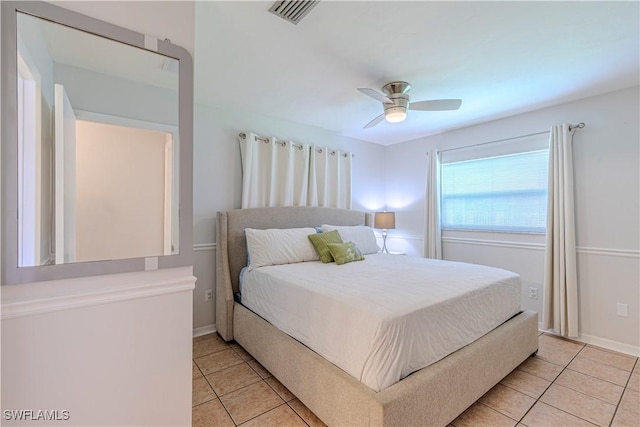 bedroom with light tile patterned floors, visible vents, baseboards, and ceiling fan