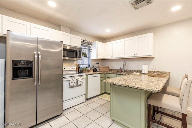 kitchen with a peninsula, white cabinetry, visible vents, recessed lighting, and stainless steel appliances