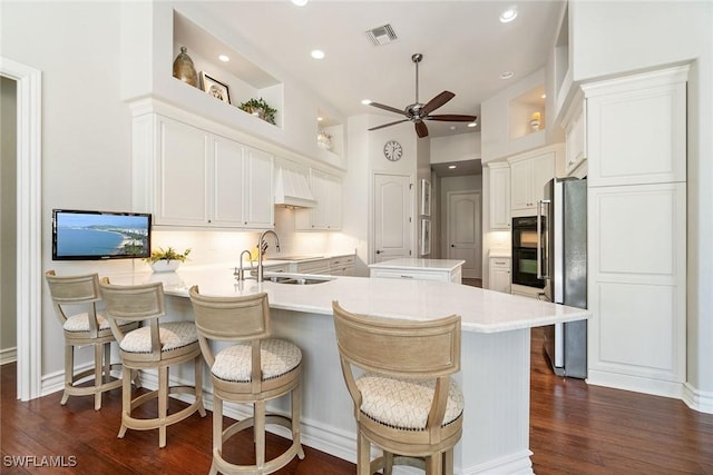 12581 Vittoria Way, Fort Myers, FL 33912 - kitchen with a peninsula, a ceiling fan, a sink, dark wood-style floors, and light countertops