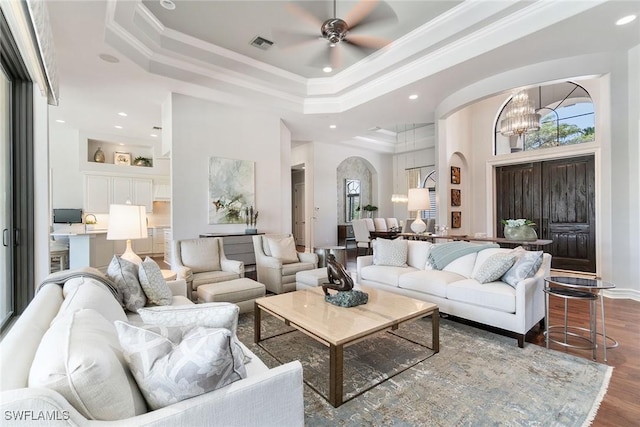 12581 Vittoria Way, Fort Myers, FL 33912 - living room featuring a chandelier, a tray ceiling, arched walkways, crown molding, and ceiling fan