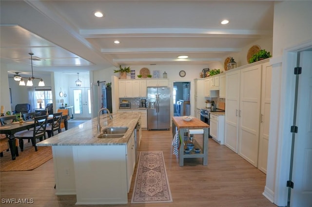 2533 SW 17th Pl, Cape Coral, FL 33914 - kitchen featuring beamed ceiling, a kitchen island with sink, stainless steel appliances, a sink, and backsplash