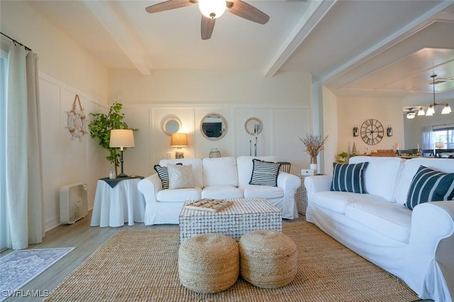 2533 SW 17th Pl, Cape Coral, FL 33914 - living room with ceiling fan with notable chandelier, beamed ceiling, wood finished floors, and a decorative wall