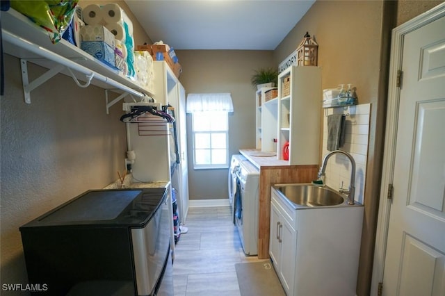 2533 SW 17th Pl, Cape Coral, FL 33914 - laundry room with independent washer and dryer, cabinet space, a sink, and baseboards