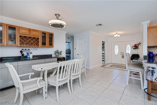 4238 Gardner Dr, Port Charlotte, FL 33952 - dining room with crown molding, wet bar, baseboards, and light tile patterned floors
