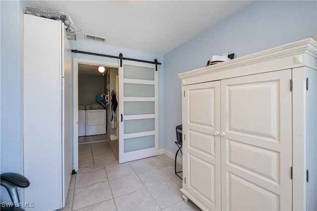 4238 Gardner Dr, Port Charlotte, FL 33952 - interior space featuring light tile patterned floors, visible vents, a barn door, and washer and clothes dryer