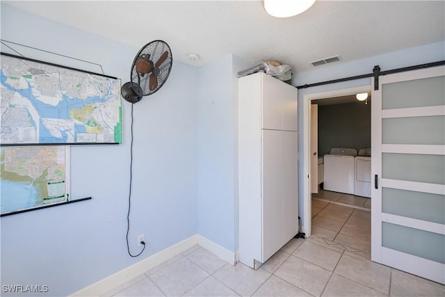 4238 Gardner Dr, Port Charlotte, FL 33952 - hallway featuring light tile patterned flooring, a barn door, baseboards, visible vents, and washing machine and dryer