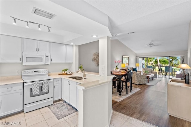 701 Augusta Blvd Unit 701-7, Naples, FL 34113 - kitchen featuring white appliances, open floor plan, a sink, vaulted ceiling, and light countertops