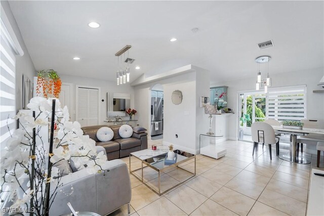 living room featuring light tile patterned flooring, baseboards, recessed lighting, and visible vents