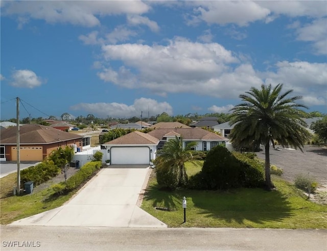 view of front of house featuring a front lawn, a residential view, driveway, and an attached garage