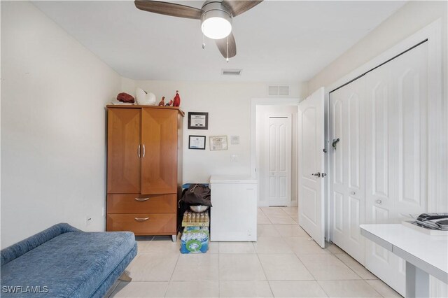 bedroom with fridge, visible vents, ceiling fan, and light tile patterned floors