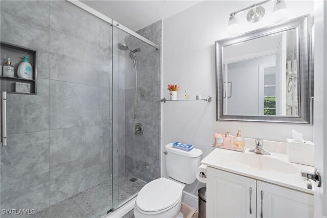 full bath with toilet, a stall shower, and vanity