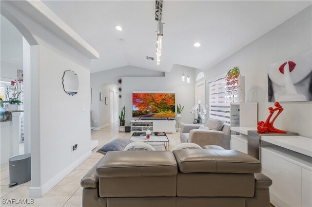 living area featuring arched walkways, lofted ceiling, recessed lighting, and light tile patterned floors