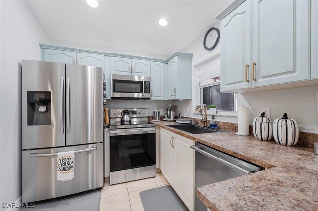 kitchen featuring light tile patterned flooring, light countertops, a sink, stainless steel appliances, and recessed lighting