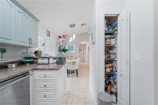 kitchen with a peninsula, stainless steel dishwasher, light tile patterned floors, visible vents, and arched walkways