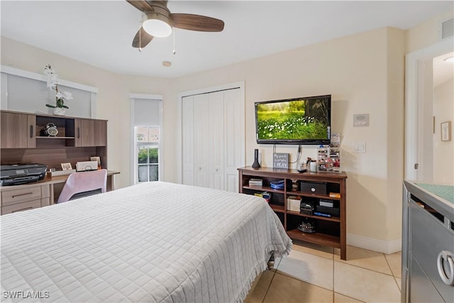 bedroom featuring a closet, visible vents, baseboards, a ceiling fan, and light tile patterned floors