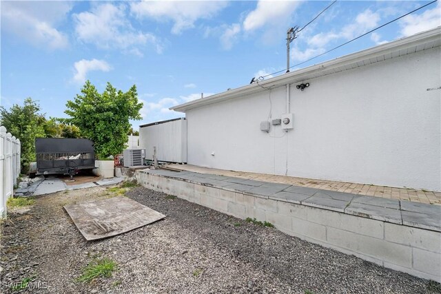 view of yard with cooling unit, fence, and a patio